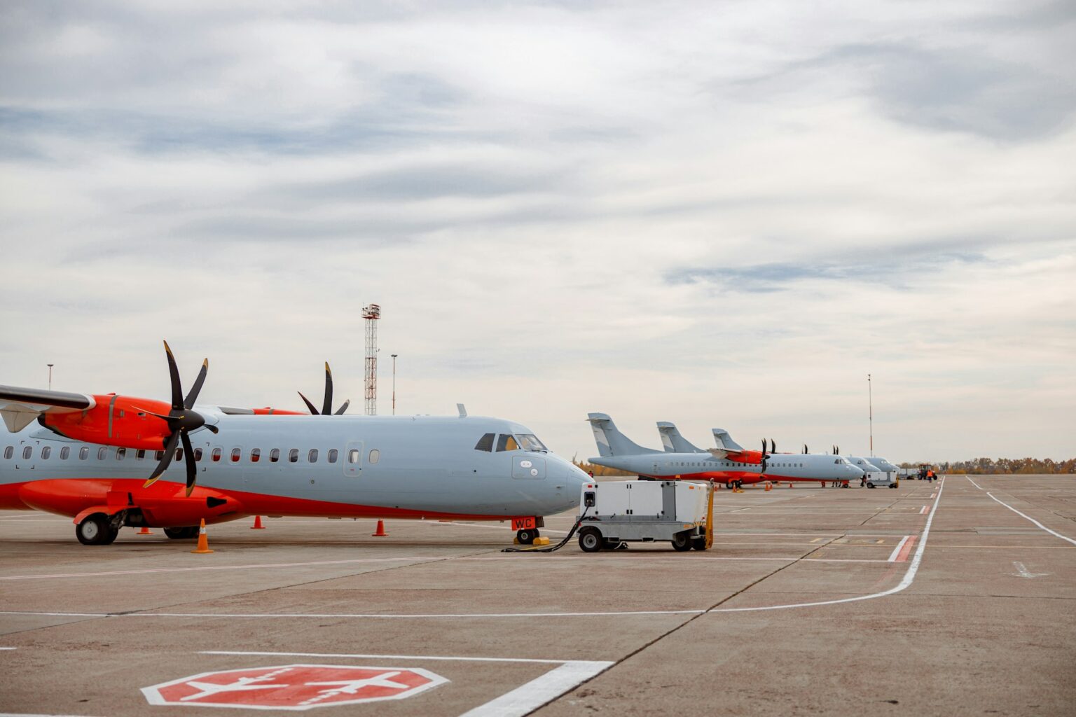 Passenger airplanes and private jets parked at airfield